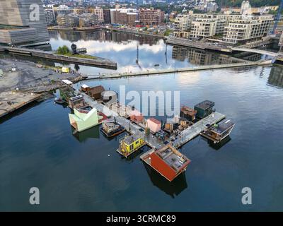 Vue aérienne d'un unique sauna flottant coloré et des allées contrastant avec l'eau sombre et la toile de fond urbaine, Oslo, Oslo, Norvège. Banque D'Images