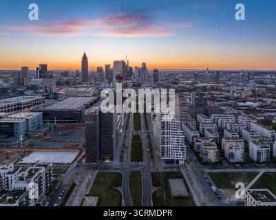 Vue aérienne des tours étincelantes de la ligne d'horizon et architecture moderne le long de Europa-Allee rencontre la douce lueur du coucher de soleil, Francfort-sur-le-main, Hesse, Allemagne. Banque D'Images