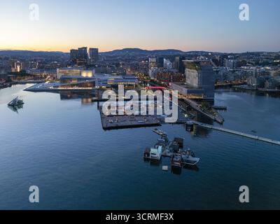 Vue aérienne de l'Opéra d'Oslo et du Musée Munch reflétée dans les eaux calmes du fjord d'Oslofjord au crépuscule, Oslo, Oslo, Norvège. Banque D'Images