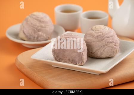 Taro pâtisseries feuilletées pour le thé de l'après-midi des fêtes de Mid Autumn Festival sur fond de table orange. Banque D'Images