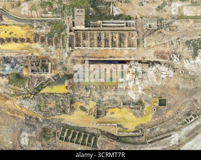 Une vue aérienne de la terre oxydée et des structures abandonnées des mines de Riotinto révèle une tapisserie de teintes rouillées et une architecture en décomposition, Minas de R. Banque D'Images