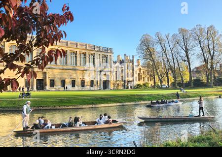 Punters dirigeant les touristes dans les bateaux punt en bois / punts sur la rivière Cam passé Trinity College Wren Library, The Backs, Université de Cambridge, Angleterre, Royaume-Uni Banque D'Images
