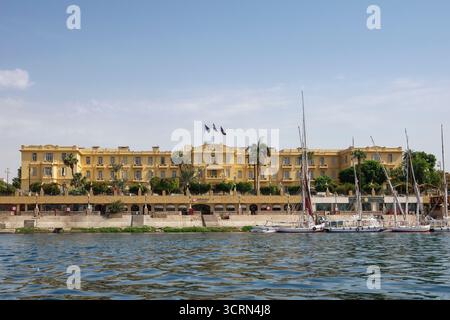 La façade avant de l'Hôtel Winter Palace sur les rives du Nil, avec felouques amarrés en face, Louxor, Egypte Banque D'Images