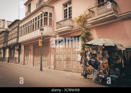 Vendeur de rue et bâtiments coloniaux dans le centre de Lima, Pérou. Banque D'Images