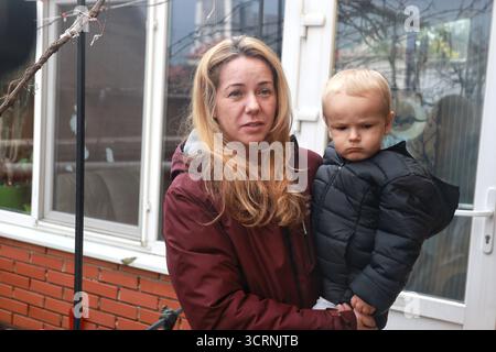 Voisine de la famille dont les membres sont morts dans le sous-sol inondé de leur maison privée Maryna Maidaniuk tient son enfant alors qu’elle répond aux questions des journalistes, Odessa, Ukraine, le 1er octobre 2025. Ces derniers jours, près de deux mois de précipitations ont frappé la ville. Les pluies anormales ont provoqué des inondations dans plusieurs rues et endommagé les infrastructures municipales. Neuf personnes ont été tuées par la tempête, dont un enfant. Banque D'Images