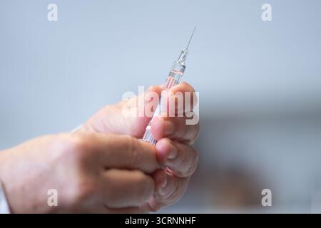 02 octobre 2025, Saxe, Dresde : un médecin tient une seringue préremplie avec un vaccin antigrippal lors d'un événement de presse à l'hôpital universitaire de Dresde pour la saison grippale 2025. Photo : Sebastian Kahnert/dpa Banque D'Images