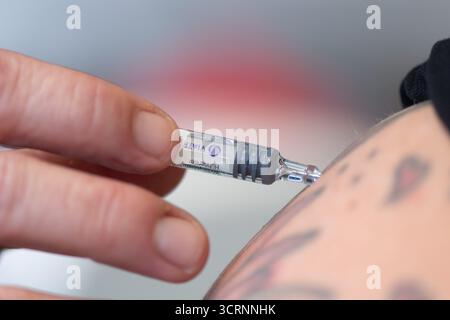 02 octobre 2025, Saxe, Dresde : un médecin tient une seringue préremplie avec un vaccin antigrippal lors d'un événement de presse à l'hôpital universitaire de Dresde pour la saison grippale 2025. Photo : Sebastian Kahnert/dpa Banque D'Images