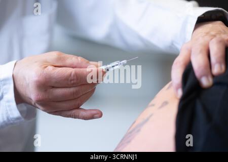 02 octobre 2025, Saxe, Dresde : un médecin tient une seringue préremplie avec un vaccin antigrippal lors d'un événement de presse à l'hôpital universitaire de Dresde pour la saison grippale 2025. Photo : Sebastian Kahnert/dpa Banque D'Images