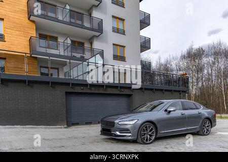 Une limousine de luxe grise et bleue à quatre portes garée dans le parking devant l'entrée du garage. En Pologne Banque D'Images