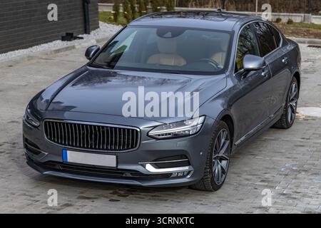 Une limousine de luxe grise et bleue à quatre portes garée dans le parking devant l'entrée du garage. En Pologne Banque D'Images