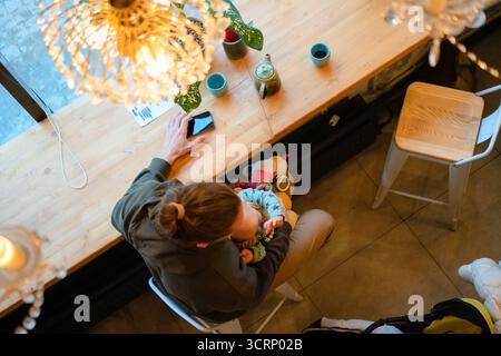 Papa souriant avec un enfant en bas âge dans un café, montrant l'amour et les soins de la famille. Parentalité moderne, temps de qualité, relation père-fils, valeurs de la famille et de la HAP Banque D'Images