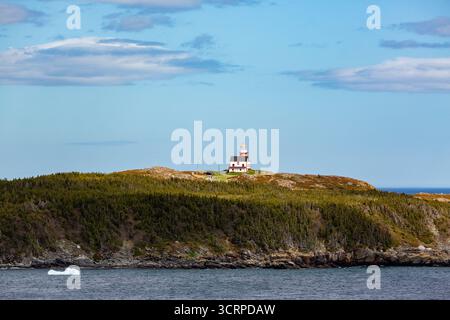 Un phare se trouve au sommet d'une colline surplombant l'océan, guidant les navires et offrant une vue panoramique pour les visiteurs. Banque D'Images
