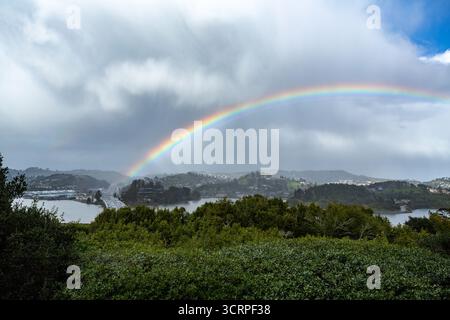 Un arc-en-ciel vibrant arque le ciel, connectant le paysage avec son spectre coloré. La présence de l'arc-en-ciel ajoute une touche de magie à la scène, Banque D'Images