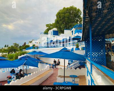 Vue panoramique sur la côte depuis le Café des délices à Sidi Bou Said, Tunis, parasols bleus et horizon marin. Capturé le 23 septembre 2025 Banque D'Images