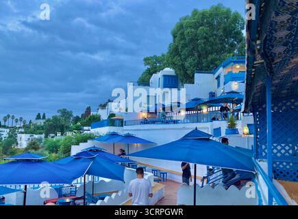 Vue panoramique sur la côte depuis le Café des délices à Sidi Bou Said, Tunis, parasols bleus et horizon marin. Capturé le 23 septembre 2025 Banque D'Images
