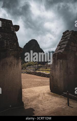 Vue de la montagne Huayna Picchu encadrée par des murs de pierre Inca à Machu Picchu, Pérou. Banque D'Images