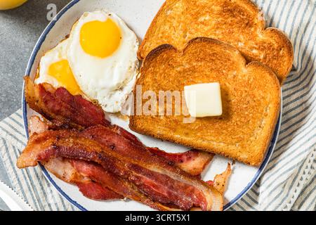 Petit-déjeuner sain aux œufs de bacon américain et pain grillé avec jus d'orange Banque D'Images