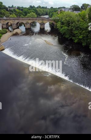 Vue aérienne du pont de pierre historique traversant la rivière Wharfe à Wetherby avec déversoir en premier plan Banque D'Images