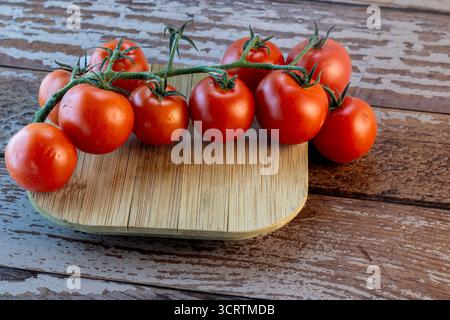 Tomates mûries sur planche à découper en bois Banque D'Images