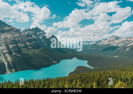 Lac turquoise niché entre une chaîne de montagnes couverte de pins. Banque D'Images