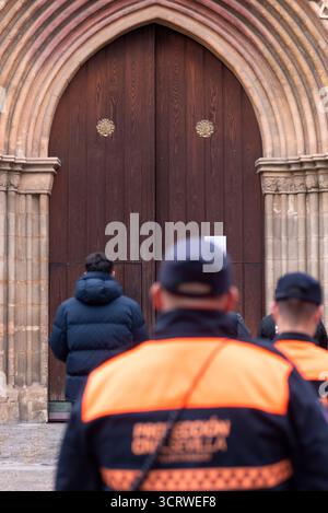 Un officier de la protection civile monte la garde devant l'église Santa Marina en attendant le cortège final de Pâques à Séville, en Espagne. Banque D'Images