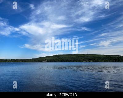 Vue panoramique sur le lac d'été avec collines forestières et nuages à Vuokatti, Finlande Banque D'Images