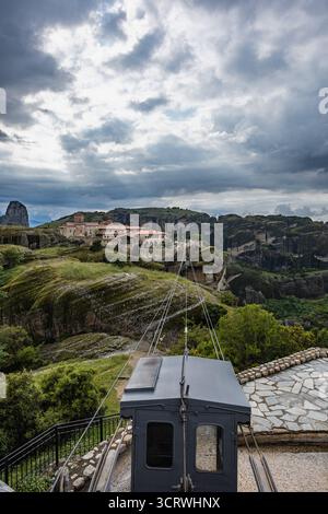 Téléphérique menant au monastère de Varlaam à Météores, Grèce, site du patrimoine mondial de l'UNESCO, sous un ciel nuageux spectaculaire au-dessus de formations rocheuses. Banque D'Images