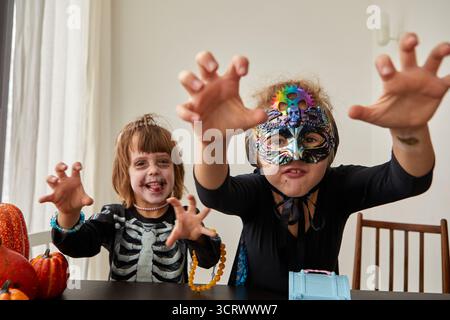 Deux enfants sont joyeusement dans leurs costumes d'Halloween, capturant la joie festive et la créativité de la saison Banque D'Images