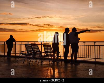 Coucher de soleil naviguant sur l'océan ouvert à bord d'un bateau de croisière. Prise sur la côte norvégienne. Banque D'Images