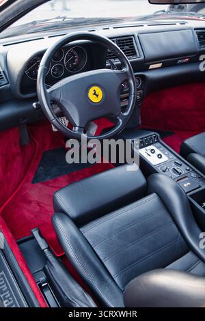 Vilnius, Lituanie - 2025-09-20 - intérieur Ferrari classique avec velours rouge et cuir noir, vue du siège conducteur et du tableau de bord Banque D'Images