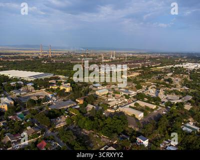 Une vue aérienne de Rustavi, Géorgie, mettant en valeur un mélange de complexes industriels avec de hautes cheminées et les zones résidentielles environnantes au milieu des espaces verts Banque D'Images