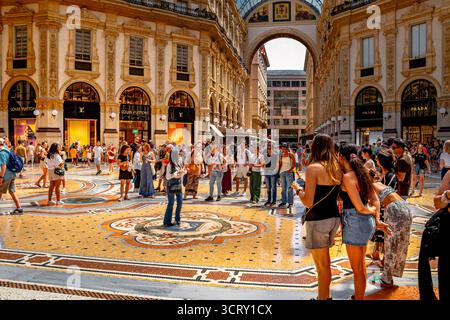 Les gens tournent sur la mosaïque du taureau, une tradition populaire à l'intérieur de la Galleria Vittorio Emanuele II, pour apporter la bonne fortune, Milan, Italie Banque D'Images