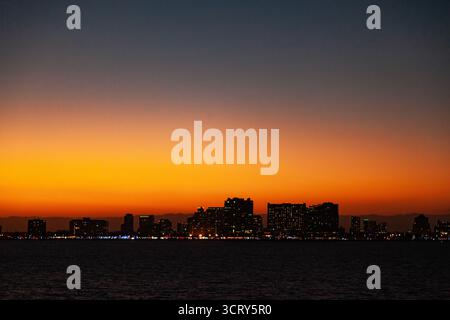 Vue nocturne époustouflante sur les gratte-ciel de la ville de Fort Lauderdale le long de la côte de l'océan Atlantique au crépuscule avec un ciel de coucher de soleil orange vibrant Banque D'Images