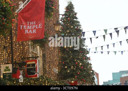 Dublin, Irlande - 03 octobre 2025 - Un grand arbre de Noël avec des décorations se lève tôt sur le côté du pub Temple Bar dans le centre-ville de Dublin par un après-midi humide début octobre Banque D'Images