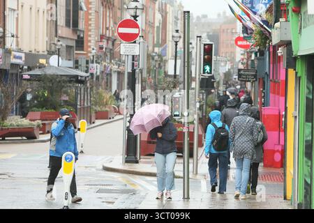 Dublin, Irlande - 03 octobre 2025 - Capel Street dans le centre-ville de Dublin par une journée humide et venteuse alors qu'une femme se bat avec un parapluie pendant la tempête Amy dans la capitale irlandaise Banque D'Images