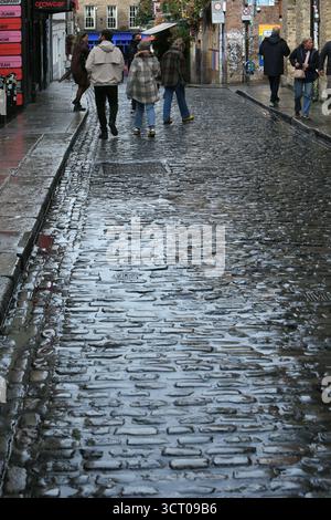 Dublin, Irlande - 03 octobre 2025 - la lumière brille sur des pavés humides sombres sur une surface de route à Temple Bar dans le centre-ville de Dublin par une journée humide et venteuse alors que la tempête Amy approche dans la capitale irlandaise Banque D'Images