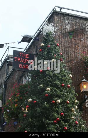 Dublin, Irlande - 03 octobre 2025 - Un grand arbre de Noël avec des décorations se lève tôt sur le côté du pub Temple Bar dans le centre-ville de Dublin par un après-midi humide début octobre Banque D'Images