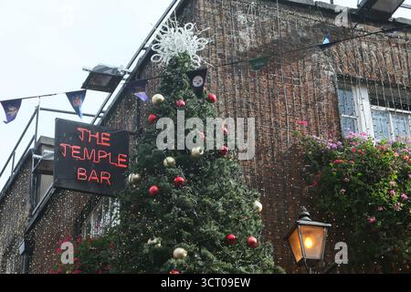 Dublin, Irlande - 03 octobre 2025 - Un grand arbre de Noël avec des décorations se lève tôt sur le côté du pub Temple Bar dans le centre-ville de Dublin par un après-midi humide début octobre Banque D'Images