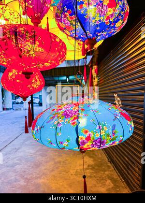 Lanternes colorées à motifs floraux suspendues dans une rangée à un marché de rue lors d'une célébration de festival dans la nuit ipoh malaisie Banque D'Images