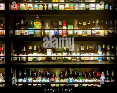 Une variété de bouteilles de bière affichées sur les étagères dans un magasin d'alcool avec diverses étiquettes et emballages colorés sous un éclairage lumineux ipoh malaysia Banque D'Images