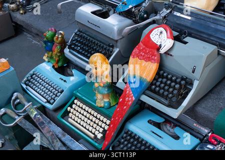 Une collection de machines à écrire vintage, dont une verte avec un perroquet dessus. Les machines à écrire sont disposées en rangée, la machine à écrire perroquet en t Banque D'Images