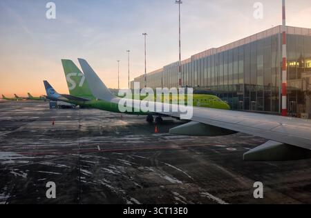 Novossibirsk, Russie - 15 janvier 2025 : avion vert de S7 Airlines stationné à l'aéroport moderne à Sunrize avec le sol givré du terrain de décollage de l'aérodrome Banque D'Images