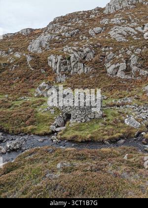 Alltanabradhan Mill, une ruine de l'ère Clearances dans les Highlands écossais près d'Achmelvich sur la NC500. Les murs de pierre et les vieilles meules sont encore éparpillés. Banque D'Images