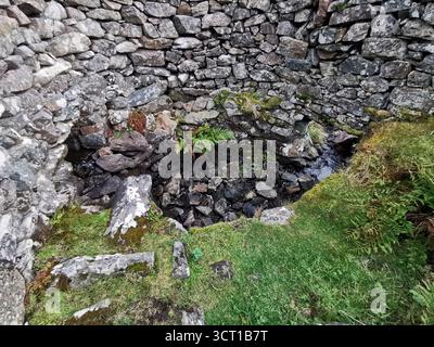 Alltanabradhan Mill, une ruine de l'ère Clearances dans les Highlands écossais près d'Achmelvich sur la NC500. Les murs de pierre et les vieilles meules sont encore éparpillés. Banque D'Images