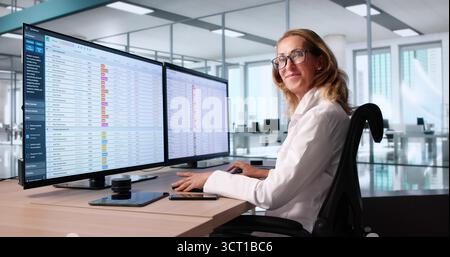 Médecin faisant des codes de facturation médicale tableur et comptabilité sur plusieurs ordinateurs Banque D'Images