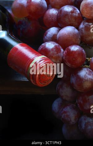 Raisins rouges avec bouteille de vin rouge Banque D'Images