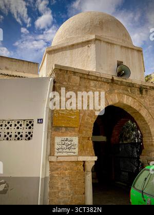Mosquée islamique et école à Tunis, Tunisie. Dôme carrelé vert, façade en pierre sculptée et détails architecturaux traditionnels. Capturé le 22 septembre 2025 Banque D'Images