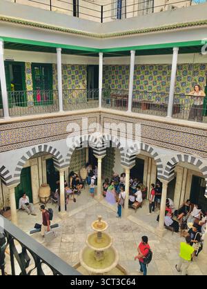 Cour intérieure de Dar Bach Hamba à Tunis, Tunisie. Architecture traditionnelle, arches rayées, murs carrelés et fontaine centrale. 22 septembre 2025 Banque D'Images