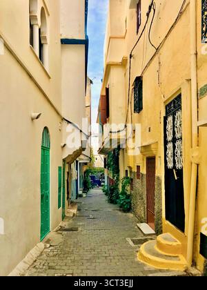 Ruelle colorée dans l'ancienne Kasbah Medina de Tanger, Maroc, avec des murs carrelés et des pavés humides. Photographié le 8 novembre 2019. Banque D'Images