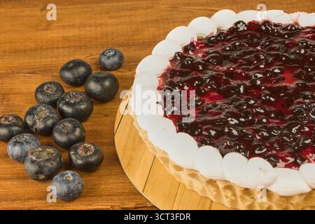 Cheesecake garni de gelée de sureau. Gros plan sur un fond en bois rustique avec espace de copie Banque D'Images